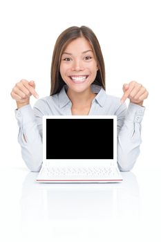 Excited woman sitting pointing at netbook laptop screen with copy space. Asian / Caucasian woman sitting at table isolated on white.