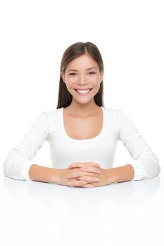 Beautiful young woman smiling sitting by table. Serene Asian Caucasian woman in white isolated on white background.