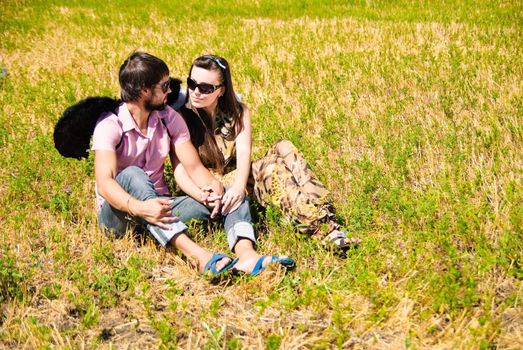 Young happy couple on the field. Shoot on the nature.