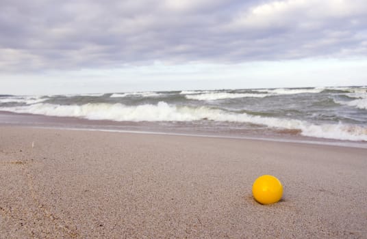 yellow ball on the morning sea beach sand