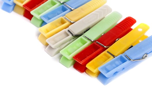Close up view of some colorful cloth pegs isolated on a white background.