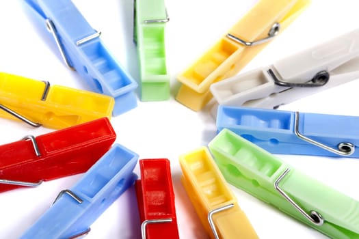 Close up view of some colorful cloth pegs isolated on a white background.