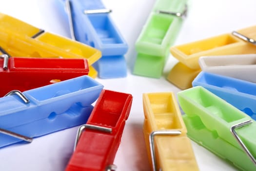 Close up view of some colorful cloth pegs isolated on a white background.