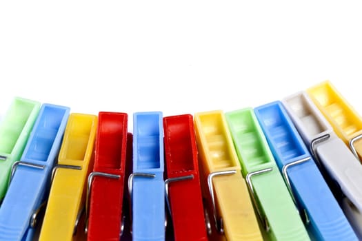 Close up view of some colorful cloth pegs isolated on a white background.
