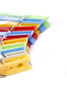 Close up view of some colorful cloth pegs isolated on a white background.