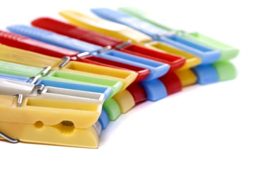 Close up view of some colorful cloth pegs isolated on a white background.