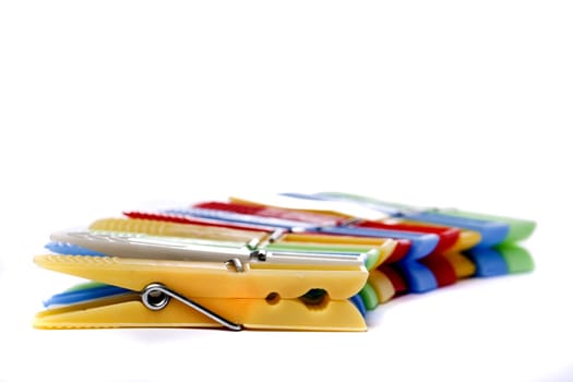 Close up view of some colorful cloth pegs isolated on a white background.