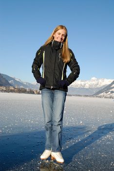 Young woman ice skating on frozen lake on a sunny day