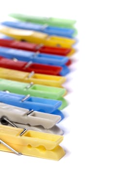 Close up view of some colorful cloth pegs isolated on a white background.