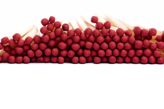 Close up view of a bunch of matches with red heads on a white background.