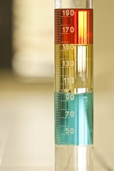 Close up view of a test tube with some different liquid solutions.