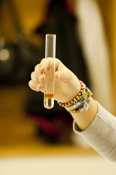 Close up view of a student of chemistry holding a test tube.