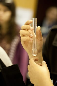 Close up view of a student of chemistry holding a test tube.