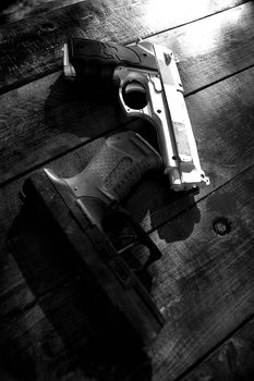 Two toy guns on top a wooden table.