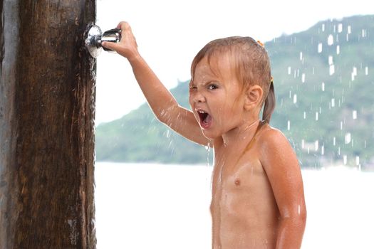 little girl in the sea under a shower valve closes