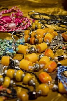 Several colored woman accessories on the table, including necklaces and bracelets.
