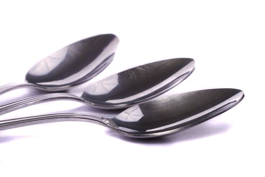Close up view detail of some spoons isolated on a white background.