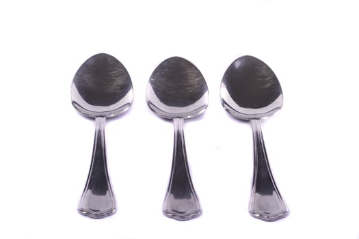 Close up view detail of some spoons isolated on a white background.