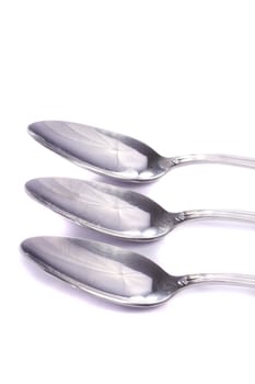 Close up view detail of some spoons isolated on a white background.