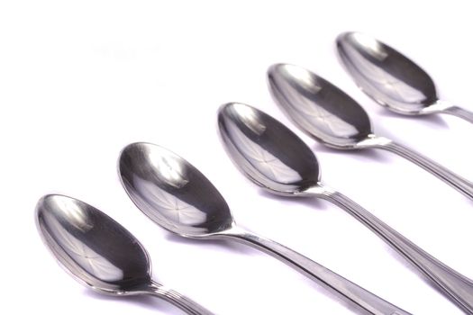 Close up view detail of some spoons isolated on a white background.