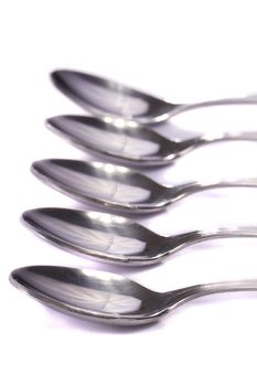 Close up view detail of some spoons isolated on a white background.