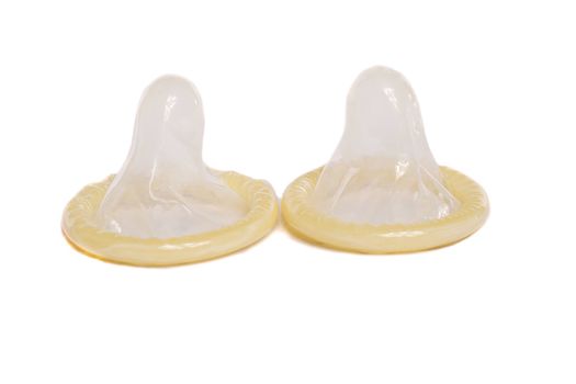 Close view of two condoms isolated on a white background.