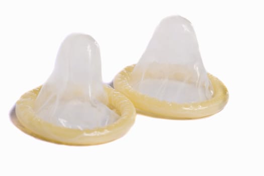 Close view of two condoms isolated on a white background.