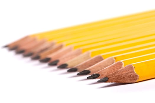 Close up view of a bunch of yellow pencils isolated on a white background.