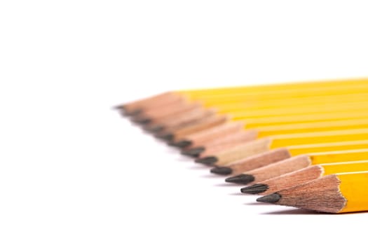 Close up view of a bunch of yellow pencils isolated on a white background.