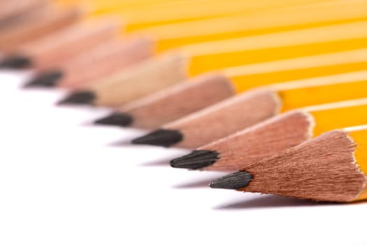 Close up view of a bunch of yellow pencils isolated on a white background.