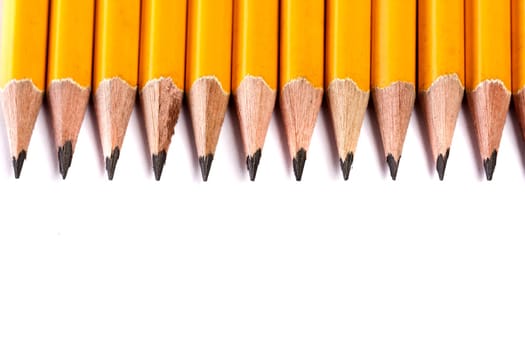 Close up view of a bunch of yellow pencils isolated on a white background.