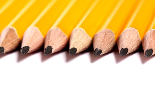 Close up view of a bunch of yellow pencils isolated on a white background.