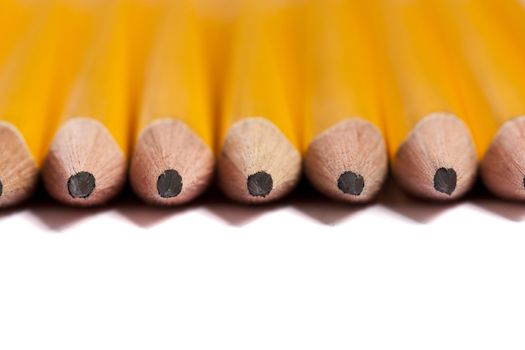 Close up view of a bunch of yellow pencils isolated on a white background.