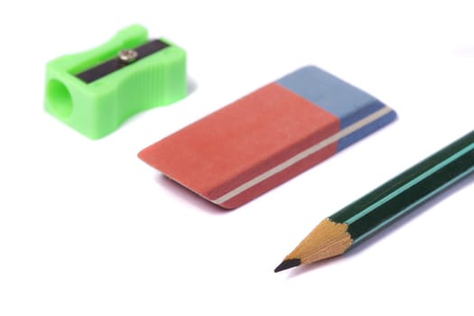 View of a pencil sharpener, an eraser and a pencil isolated on a white background.