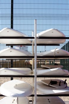 View of a bunch of aligned surfer boards piled on top of each other.