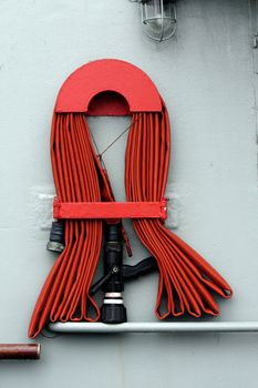 View of a red fire hose wrapped on a boat.