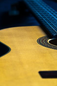 Detail shot of a beautiful acoustic guitar on dark velvet