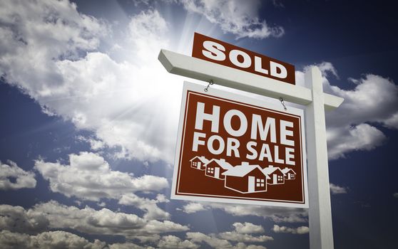 Red Sold Home For Sale Real Estate Sign Over Beautiful Clouds and Blue Sky.