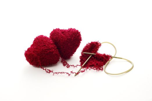 One heart knitted from two red heart shaped clews