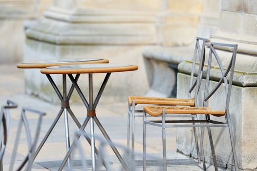 Round tables and wicker chairs in cafe in Paris. Photo with tilt-shift effect