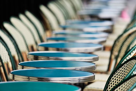 Several round tables in the typical cafe in Paris. Photo with tilt-shift effect