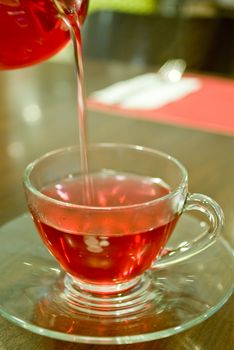 The hot tea pouring to tea cup