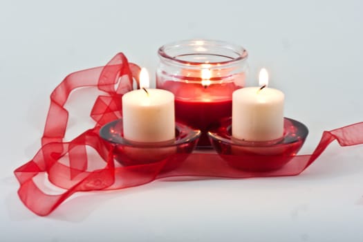 Set of three candles with flame and red ribbon