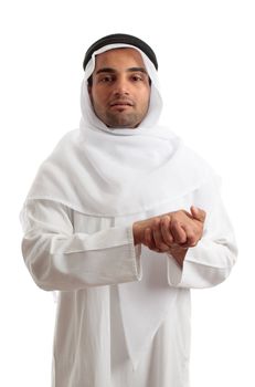 An ethnic man dressed in arab , saudi or other middle eastern attire.  He is wearing a white robe, ghutra and igal.  White background.