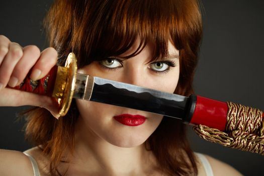 A young woman gets out of the sheath Japanese sword