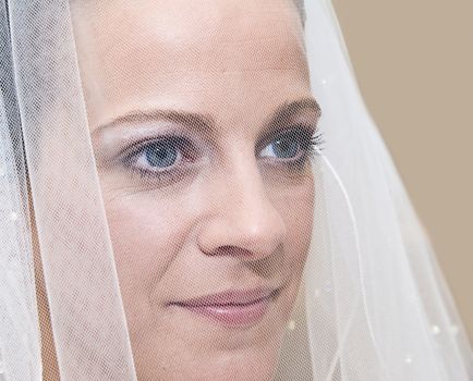 Close up portrait of beautiful young bride behind veil