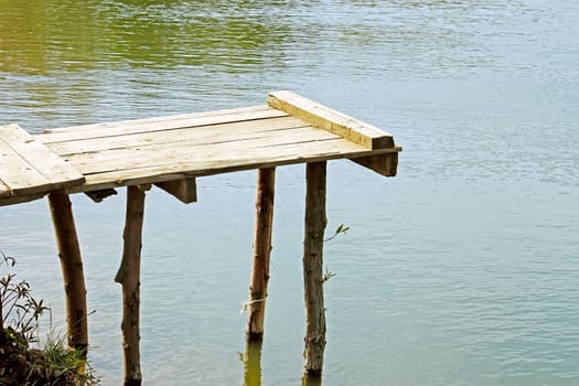 Handmade wooden springboard at the village pond