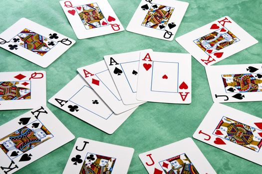 Close up view of a circle of playing cards spread on a green cloth table.