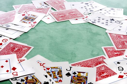 Close up view of a bunch cards spread on a green cloth table.