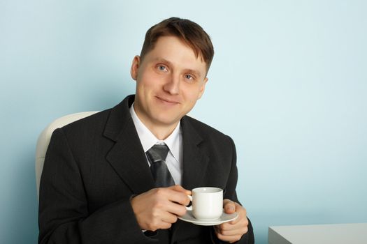 Handsome young businessman drinking coffee in the break time